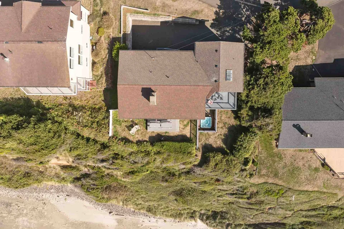 This exterior image showcases the house's backyard, complete with a pool, lush greenery, and a pathway leading directly to the beach. The open layout provides ample space for outdoor activities and relaxation, making it ideal for pets to explore and for families to enjoy together.